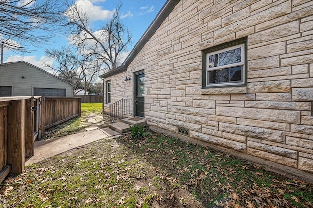 view of side of home featuring a garage and an outdoor structure