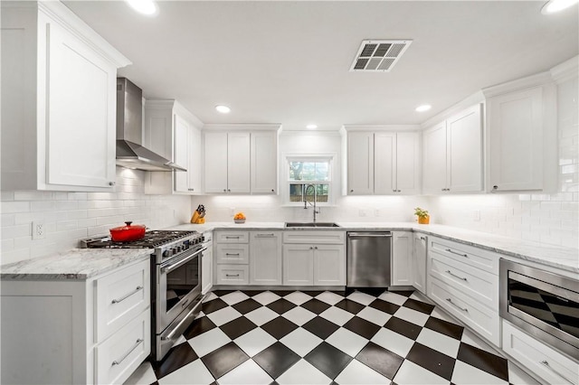 kitchen featuring stainless steel appliances, white cabinetry, wall chimney exhaust hood, and sink