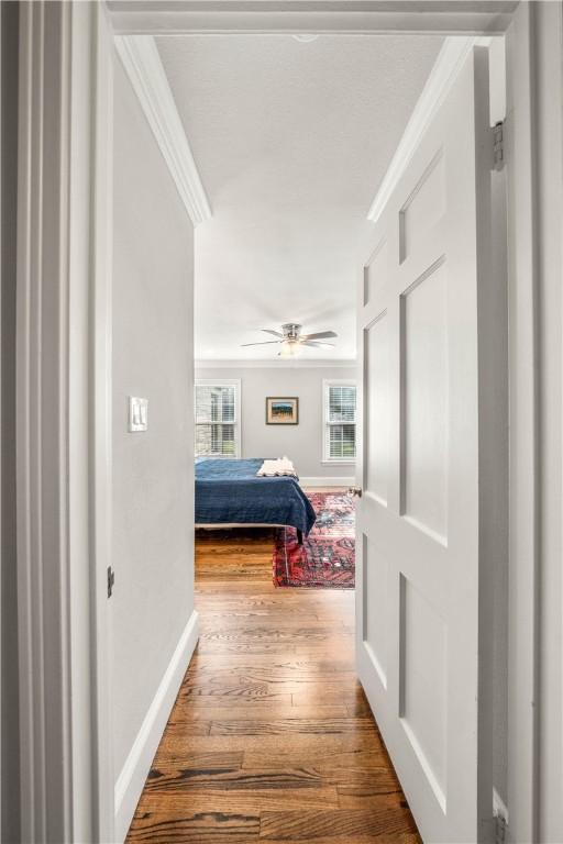 corridor featuring hardwood / wood-style flooring and ornamental molding