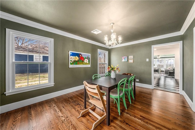 dining room featuring hardwood / wood-style flooring, crown molding, and a chandelier