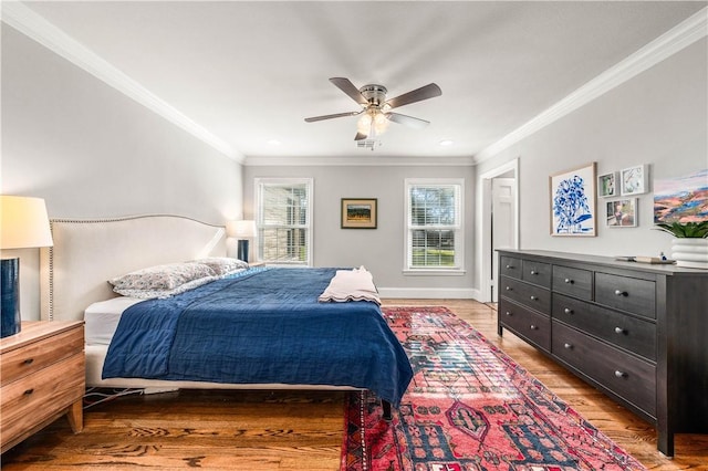 bedroom with ceiling fan, ornamental molding, and light hardwood / wood-style flooring