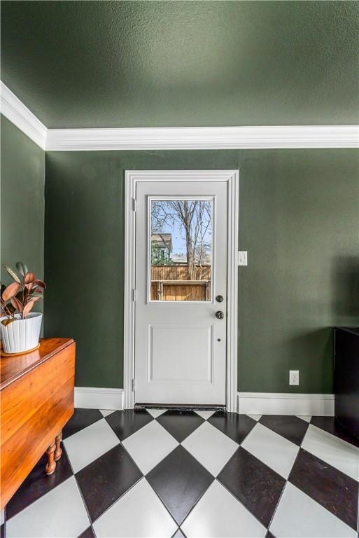 entryway with a textured ceiling and crown molding