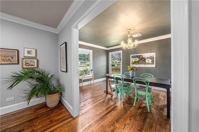 dining space featuring crown molding, hardwood / wood-style floors, and a chandelier