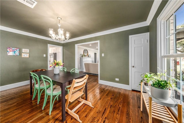 dining space featuring a wealth of natural light, ornamental molding, dark wood-type flooring, and an inviting chandelier