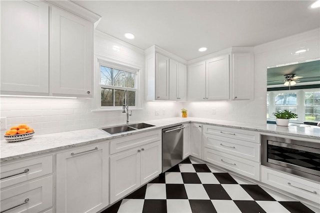 kitchen with decorative backsplash, stainless steel appliances, white cabinetry, and sink