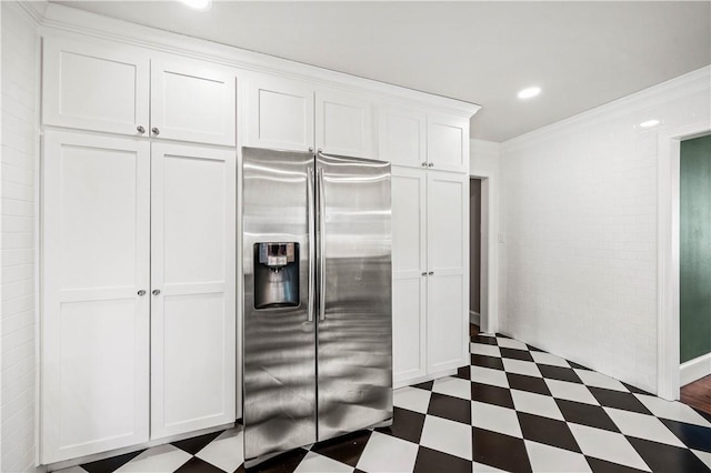 kitchen with white cabinets, ornamental molding, and stainless steel refrigerator with ice dispenser