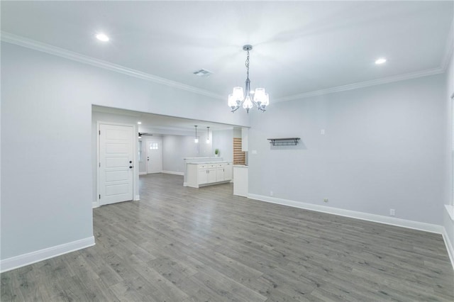 unfurnished living room featuring crown molding, a chandelier, and hardwood / wood-style floors