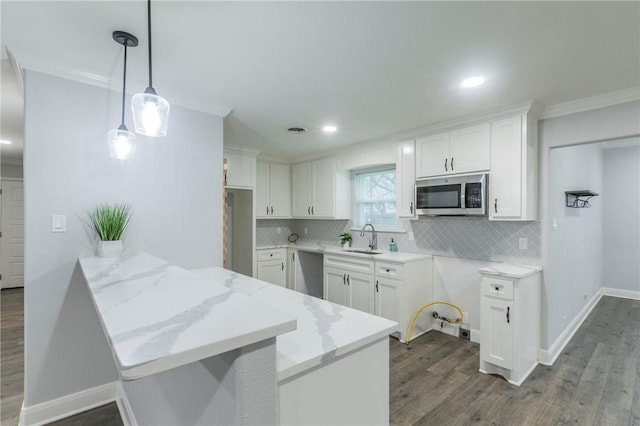 kitchen featuring appliances with stainless steel finishes, kitchen peninsula, sink, and white cabinets