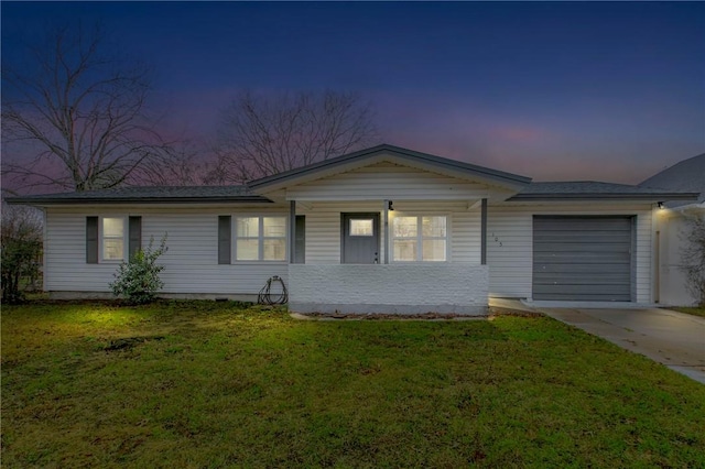 ranch-style home with a garage and a lawn