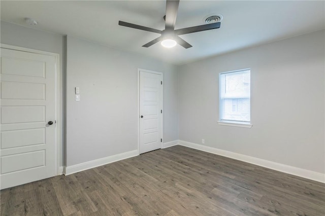 unfurnished room with dark hardwood / wood-style floors and ceiling fan