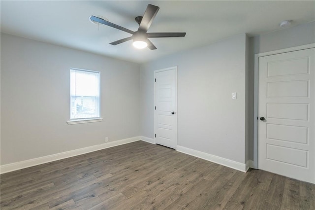 spare room with dark hardwood / wood-style floors and ceiling fan