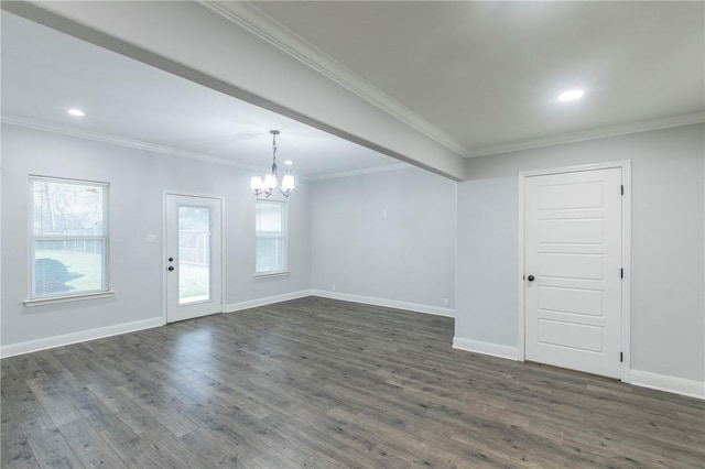 empty room featuring crown molding, dark hardwood / wood-style flooring, and an inviting chandelier