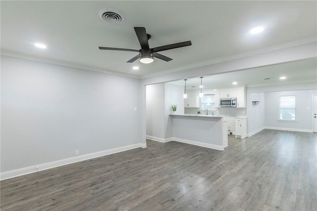 unfurnished living room with ceiling fan, ornamental molding, and dark hardwood / wood-style flooring