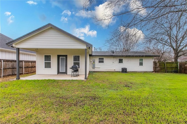 back of house featuring central AC, a lawn, and a patio area