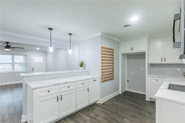 kitchen featuring dark hardwood / wood-style floors, pendant lighting, white cabinetry, decorative backsplash, and kitchen peninsula