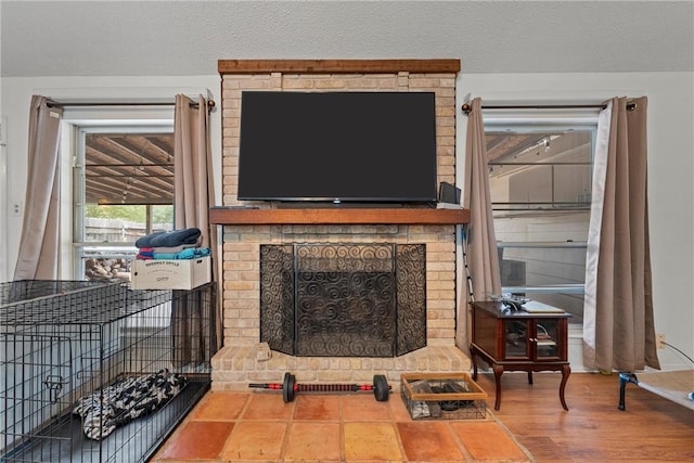 living room with a fireplace, hardwood / wood-style floors, and a textured ceiling