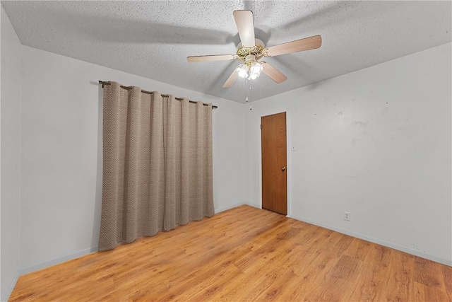 unfurnished room featuring ceiling fan, light hardwood / wood-style floors, and a textured ceiling