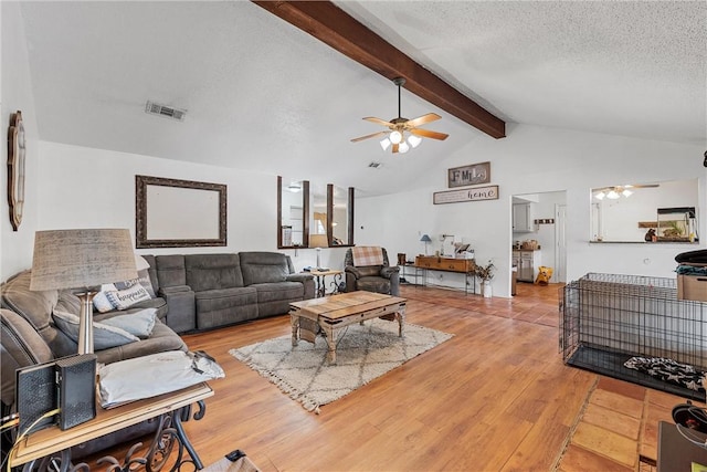 living room featuring a textured ceiling, ceiling fan, beam ceiling, high vaulted ceiling, and hardwood / wood-style floors