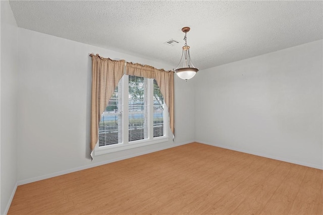 empty room featuring hardwood / wood-style floors and a textured ceiling