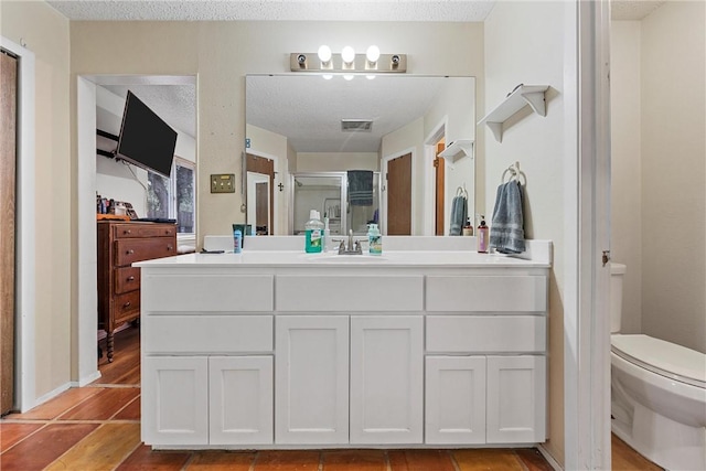 bathroom with tile patterned floors, a shower with shower door, a textured ceiling, and toilet