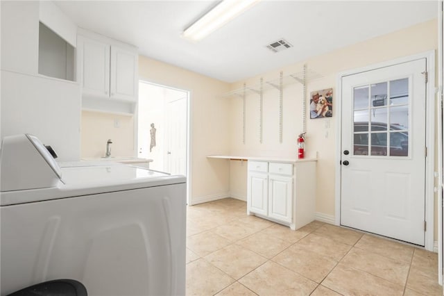 clothes washing area featuring washer and dryer, light tile patterned floors, cabinets, and sink