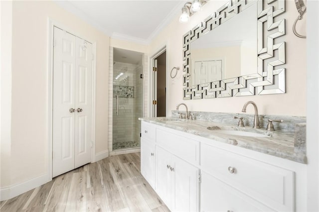 bathroom with hardwood / wood-style floors, vanity, ornamental molding, and walk in shower