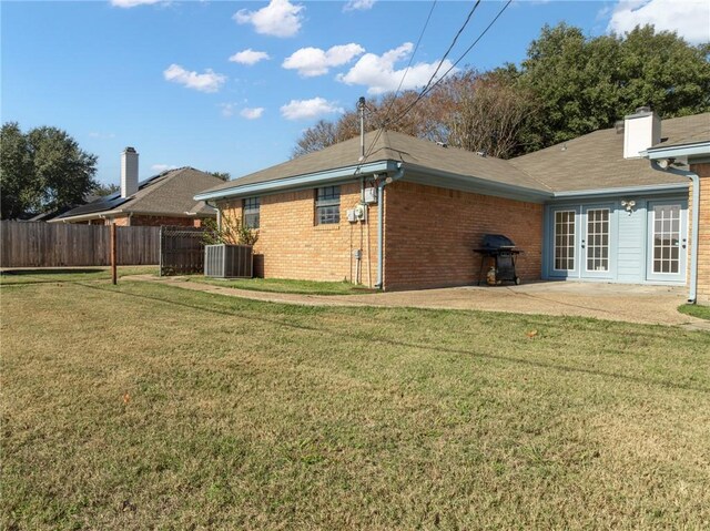 back of house with a lawn, a patio area, and central AC