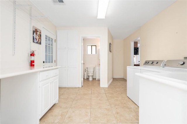 washroom with light tile patterned floors and washer and clothes dryer