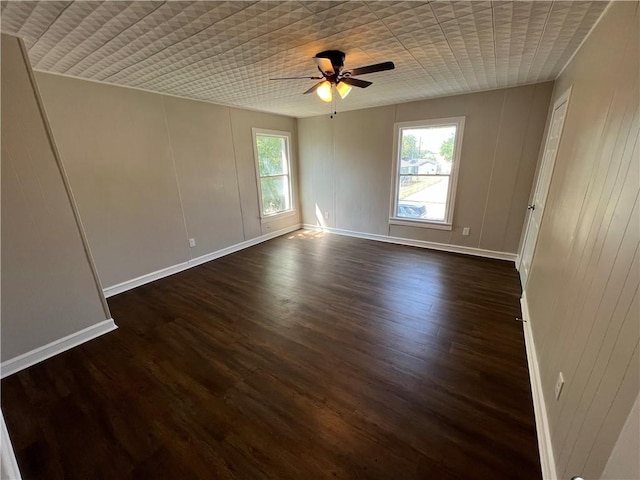 spare room featuring ceiling fan and dark wood-type flooring