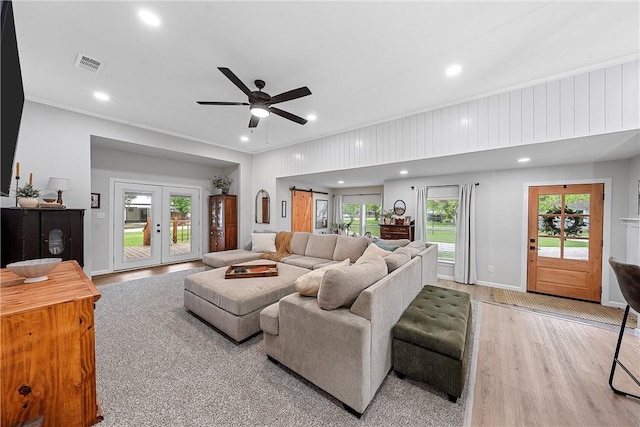 living room featuring plenty of natural light, ceiling fan, and light hardwood / wood-style flooring