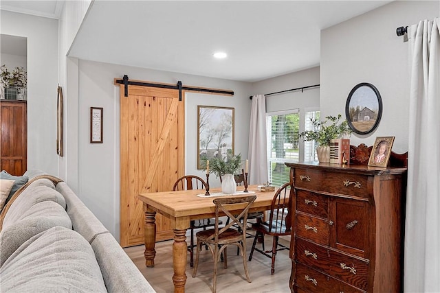 dining room featuring a barn door and light wood-type flooring