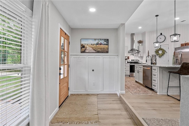 doorway to outside featuring light hardwood / wood-style floors and sink