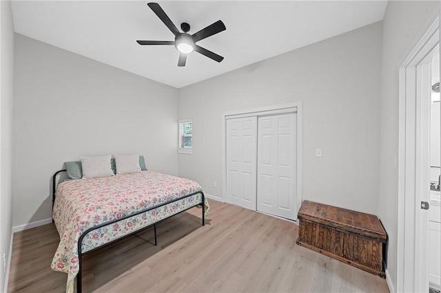 bedroom featuring ceiling fan, light wood-type flooring, and a closet