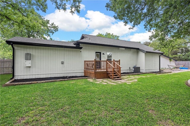 rear view of property featuring a lawn and a wooden deck