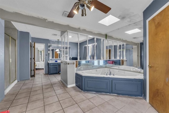 bathroom featuring a skylight, vanity, ceiling fan, tile patterned flooring, and shower with separate bathtub