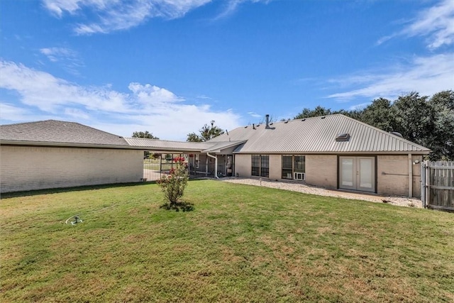 back of property with french doors and a yard