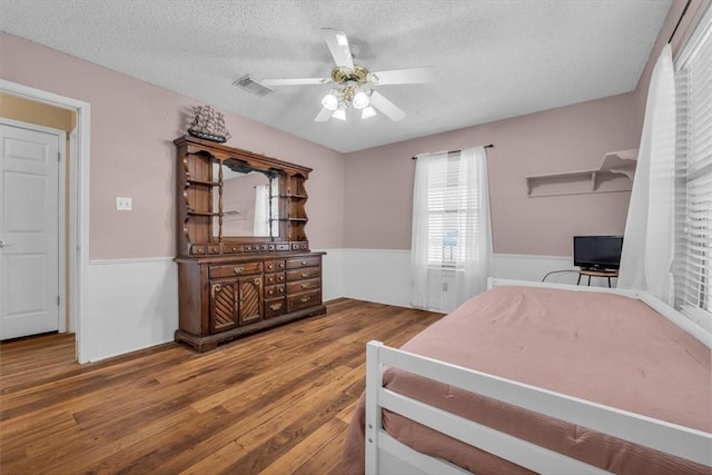 bedroom featuring ceiling fan, a textured ceiling, and hardwood / wood-style flooring