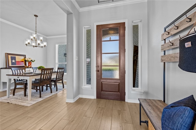 entryway with crown molding, light wood-style flooring, baseboards, and an inviting chandelier