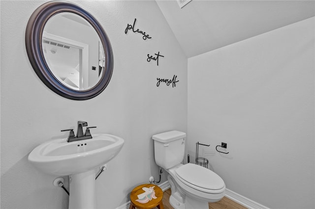 bathroom featuring vaulted ceiling, toilet, and baseboards