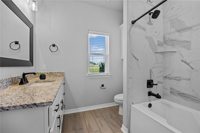 bathroom with baseboards, toilet, shower / tub combination, wood finished floors, and vanity