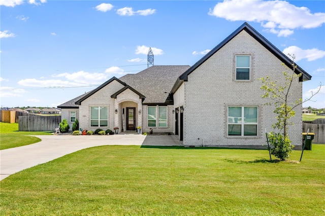 view of front of home with a front yard, brick siding, fence, and a chimney