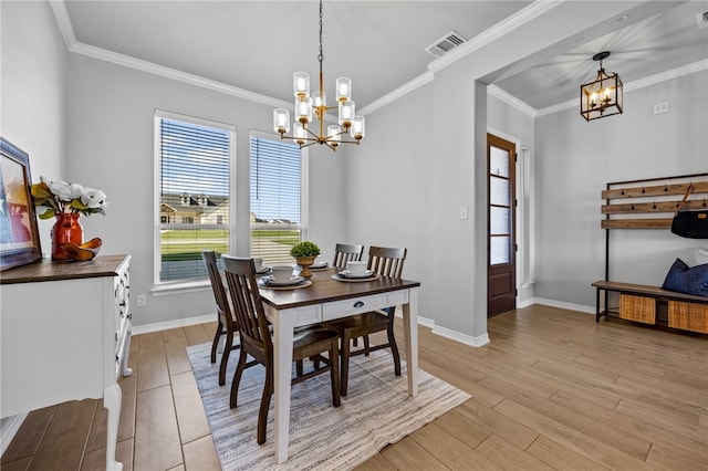 dining room with a notable chandelier, visible vents, ornamental molding, light wood-type flooring, and baseboards