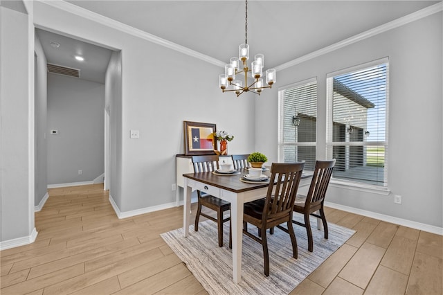 dining space featuring crown molding, light wood finished floors, visible vents, a chandelier, and baseboards