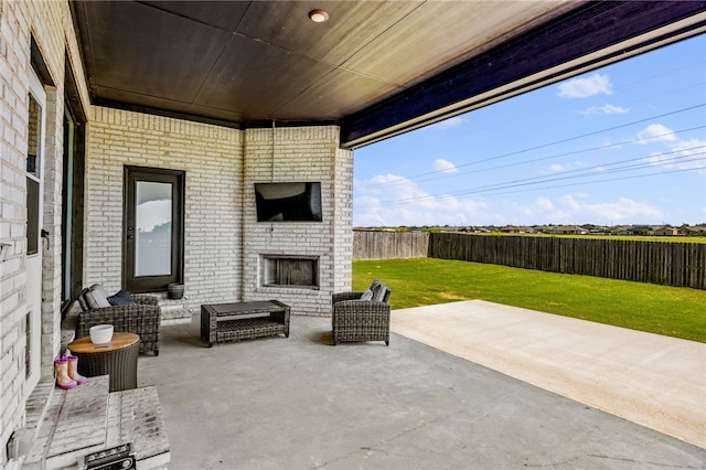 view of patio / terrace with a fenced backyard and an outdoor living space with a fireplace