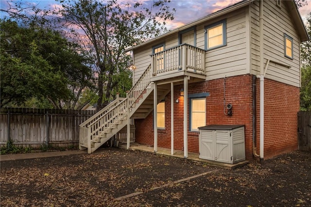 back house at dusk featuring a balcony