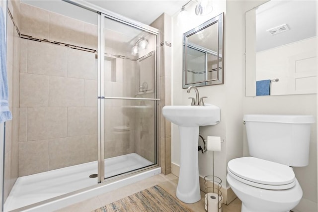 bathroom featuring tile patterned flooring, an enclosed shower, and toilet