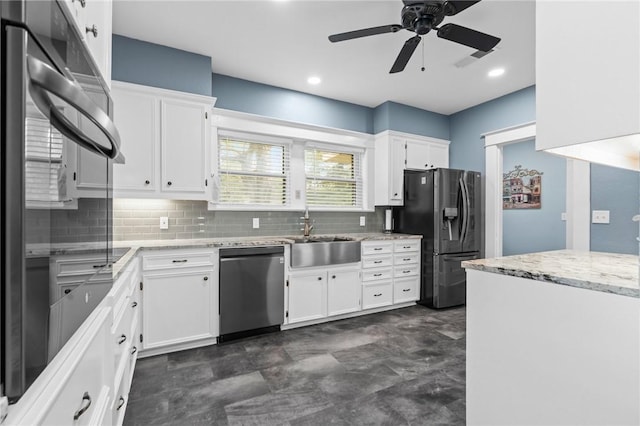 kitchen featuring ceiling fan, sink, decorative backsplash, white cabinets, and appliances with stainless steel finishes