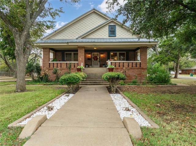 view of front of house featuring covered porch and a front yard