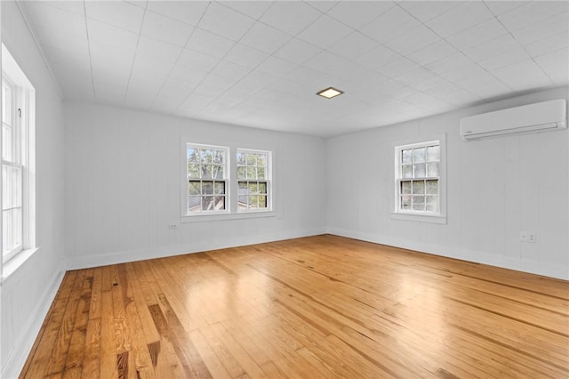 spare room with an AC wall unit and wood-type flooring