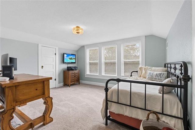 bedroom with light colored carpet and lofted ceiling